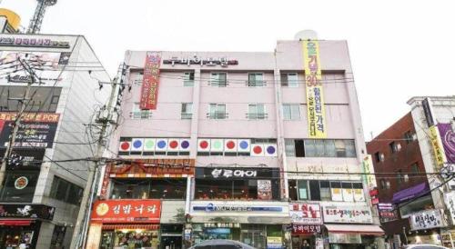 a tall white building with signs on it in a city at Dubai Motel in Daejeon