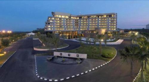 a large building with a bench in a parking lot at Labersa Grand Hotel &Convention Center in Pekanbaru