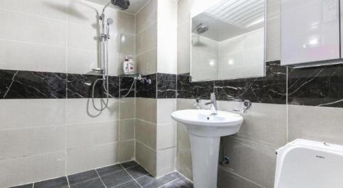 a bathroom with a sink and a shower at Dubai Motel in Daejeon