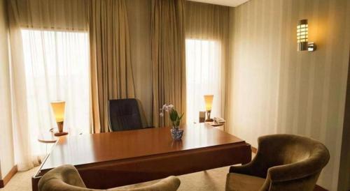 a hotel room with a desk and two chairs at Labersa Grand Hotel &Convention Center in Pekanbaru