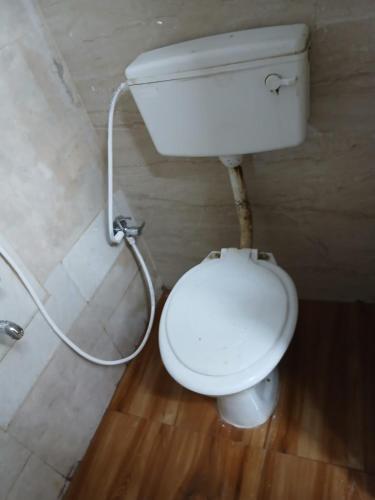 a bathroom with a white toilet in a room at Xavier Guest House in Chennai