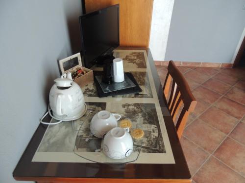 a glass table with two tea pots and a television at Da Fabiana in Bossolasco