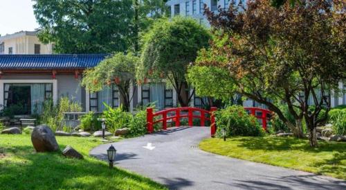 a path in a garden with a red fence at Jin Jiang Nanjing Hotel in Nanjing