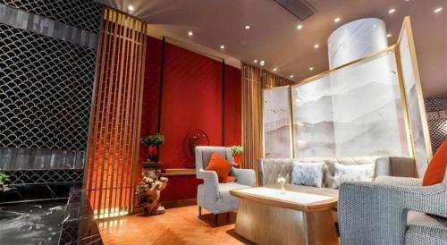 a living room with a couch and a table and chairs at Jinjiang Metropolo Hotel Nanjing Confucius Temple Branch in Nanjing