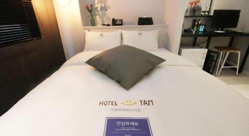 a bed in a hotel room with a pillow on it at Hotel Yam ANDONG in Andong