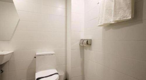 a white bathroom with a toilet and a sink at Hotel Yam ANDONG in Andong