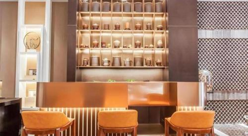 a restaurant with chairs and a counter with vases at Jinjiang Metropolo Hotel Nanjing Confucius Temple Branch in Nanjing