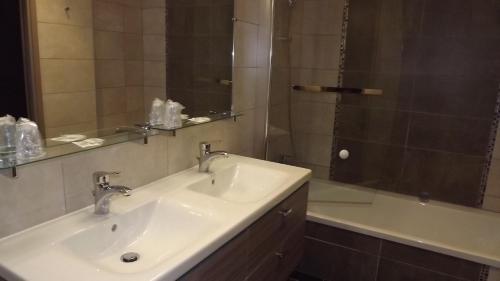 La salle de bains est pourvue d'un lavabo, d'une douche et d'une baignoire. dans l'établissement La Cocotte Gourmande, à Carantilly