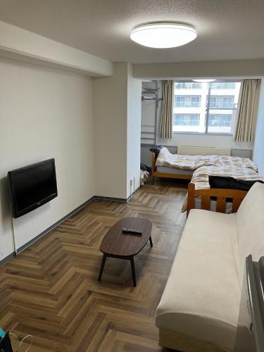 a living room with a couch and a tv at Kofu Kitaguchi Plaza Building 908 - Vacation STAY 39123v in Kofu