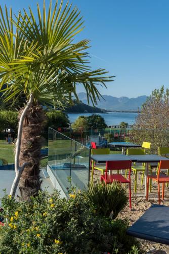 a group of tables and chairs and a palm tree at Best Western Aquakub in Aix-les-Bains