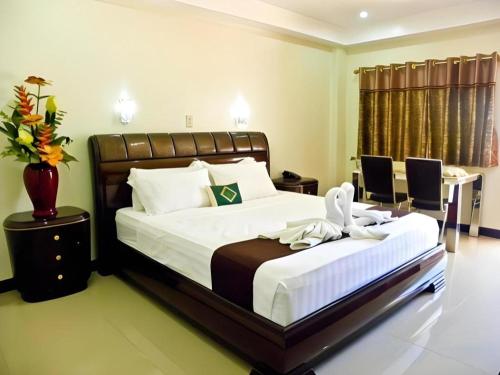 a bedroom with a large bed and a desk and a bed sidx sidx at The Premiere Business Hotel in Kalibo