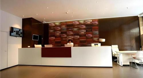 a woman sitting at a counter in a lobby at JTOUR Inn Guilin Two Rivers and Four Lakes Walmart in Guilin