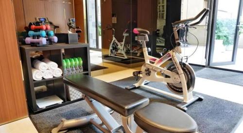 a room with a gym with a bicycle and a exercise equipment at Elysion Place Hotel Causeway Bay in Hong Kong