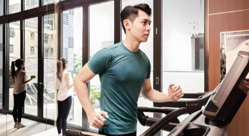 a man running on a treadmill in a gym at Elysion Place Hotel Causeway Bay in Hong Kong