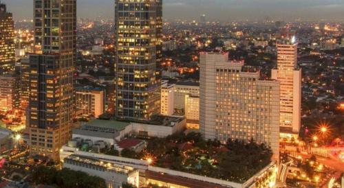 a city lit up at night with tall buildings at PARK HOTEL Cawang Jakarta in Jakarta
