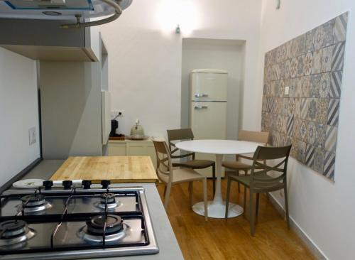 a kitchen with a stove and a table with chairs at San Pietro - PiccoloPrincipeAirbnb in Rome
