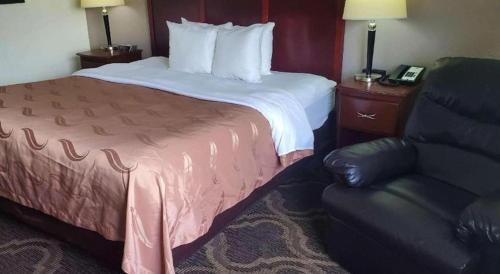 a hotel room with a bed and a chair at Quality Inn Prattville I-65 in Prattville