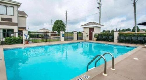 a large blue swimming pool in front of a house at Quality Inn Prattville I-65 in Prattville