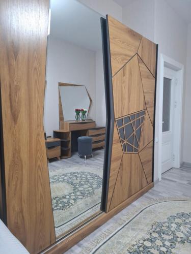 a mirror with a wooden door in a room at Однокомнатная уютная квартира для семьи in Bukhara