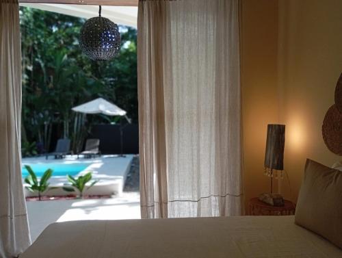 a bedroom with a bed and a view of a pool at ëkë Jungle Villa -Your Luxurious Escape Awaits in Tapantí