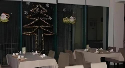 a dining room with two tables and a christmas tree at Jinjiang Inn Wuhu High-Speed Railway Station West Square in Wuhu