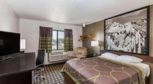 a hotel room with a bed and a flat screen tv at Super 8 By Wyndham Wayne in Wayne