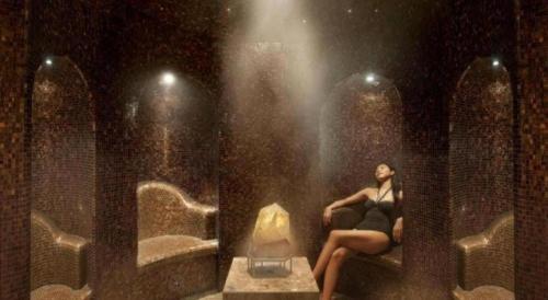 a woman sitting on a bench in front of a fire at The Landmark Mandarin Oriental, Hong Kong in Hong Kong