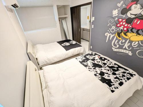 two bunk beds in a room with a mickey mouse wall at Vacation House 3 in Funabashi