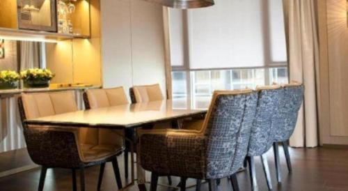 a dining table and chairs in a room with a kitchen at The Landmark Mandarin Oriental, Hong Kong in Hong Kong