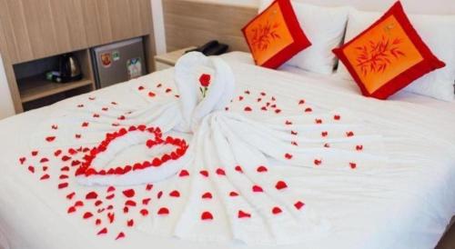 a white bed with red hearts on it at Green Hotel Da Nang in Da Nang