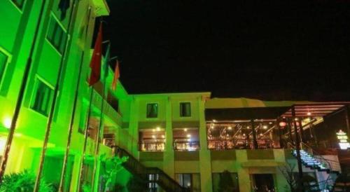 a building with green lights on it at night at Green Hotel Da Nang in Da Nang