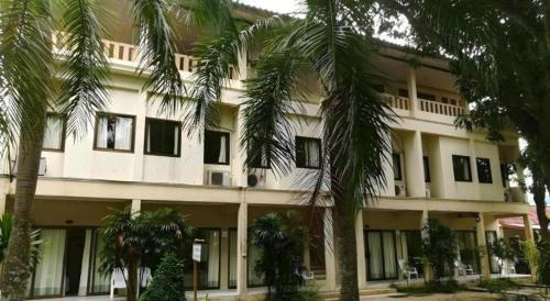 a building with palm trees in front of it at Jinta Hotel Nathon Beach in Chaweng
