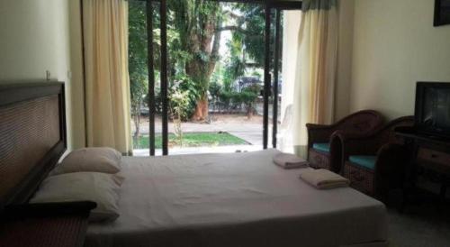 a bedroom with a large bed with a window at Jinta Hotel Nathon Beach in Chaweng