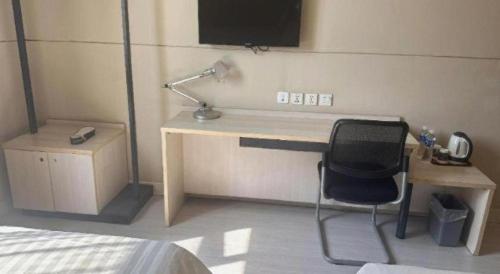 a bedroom with a desk with a chair and a bed at Jinjiang Inn Pingyao Branch in Pingyao