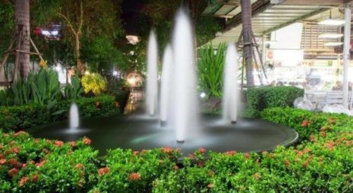 a fountain in the middle of a garden at Thanburi Hotel in Udon Thani