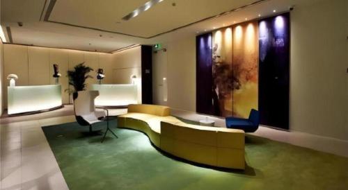 a living room with a couch and a table at Jinjiang Metropolo Shanghai Xujiahui Nanhuating Hotel in Shanghai