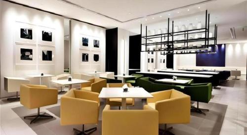 a restaurant with tables and chairs and a chandelier at Jinjiang Metropolo Shanghai Xujiahui Nanhuating Hotel in Shanghai