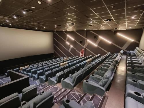 an empty auditorium with blue chairs and a blank screen at Taiyi International Hotel in Wenzhou