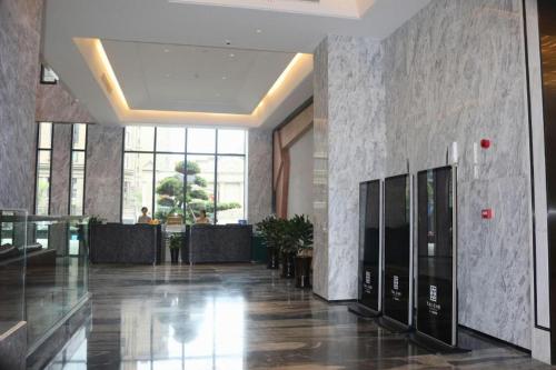 a lobby of a building with a hallway with tables at Taiyi International Hotel in Wenzhou