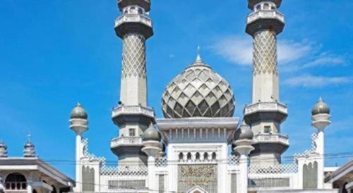 a building with two towers on top of it at OYO 643 Al Thalib 8 Syariah in Malang