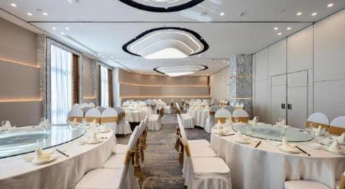 a banquet hall with white tables and white chairs at Taiyi International Hotel in Wenzhou