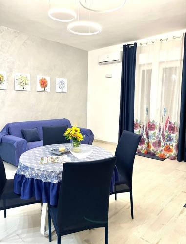 a living room with a table and a blue couch at Stefy's House in Scalea