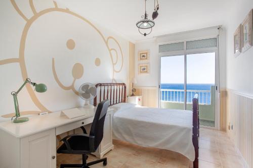 a bedroom with a desk and a bed and a window at Paraíso Atlántico in Radazul