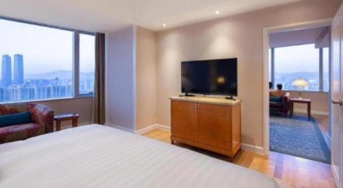 a hotel room with a bed and a flat screen tv at Kai Wah Plaza International Hotel in Kunming