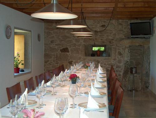 una mesa larga con copas de vino y rosas. en Casa do Fieiro, en Miñortos