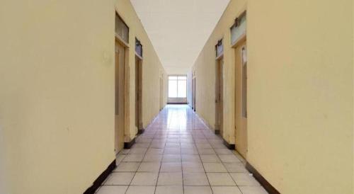 an empty hallway in a building with a window at Hotel O P3 Guest House in Bandung