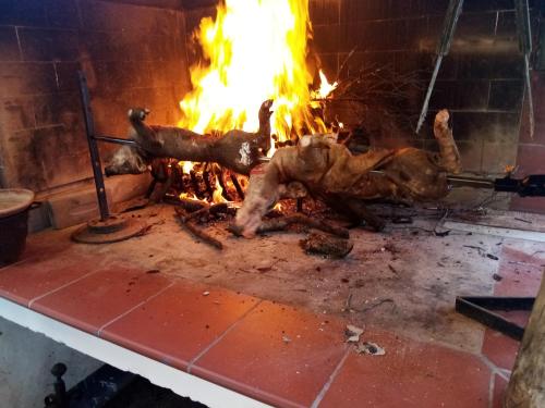 a piece of meat being cooked in a fireplace at Casa Gioconda Bed & Breakfast in Nuxis