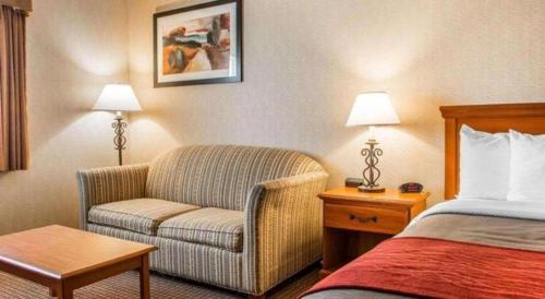 a hotel room with a bed and a couch and a chair at Quality Inn in Sidney