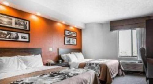 a hotel room with two beds and an orange wall at Sleep Inn Bessemer Helena in Bessemer