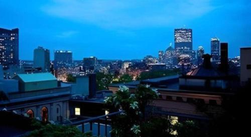 a view of a city skyline at night at Fifteen Beacon Hotel in Boston